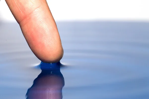 Prst dotýká vody. makro — Stock fotografie