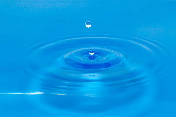 Droppe vatten i blått — Stockfoto