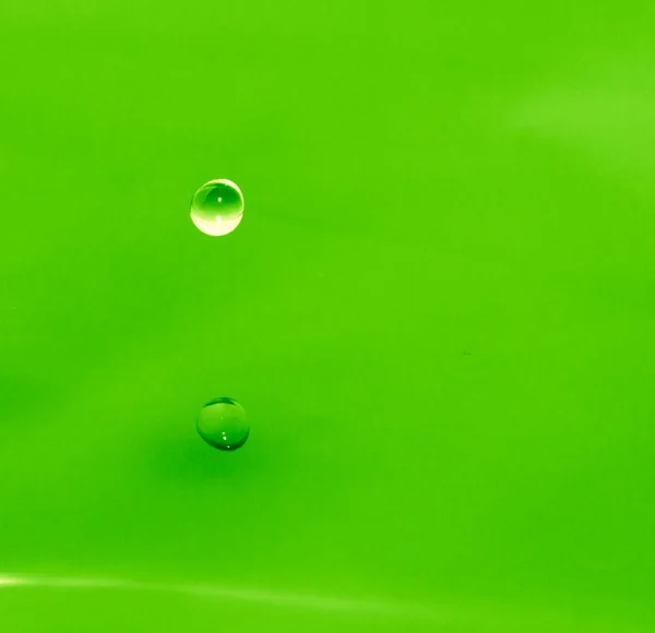 Капля воды падает в зеленую воду — стоковое фото