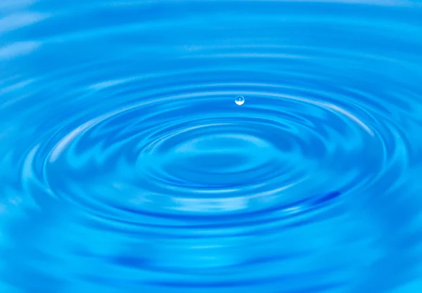 一滴水落在蓝色的水中 — 图库照片
