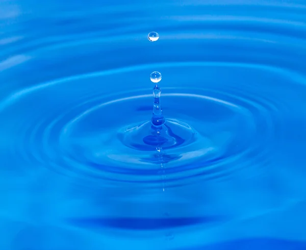青い水に落ちる水の滴 — ストック写真