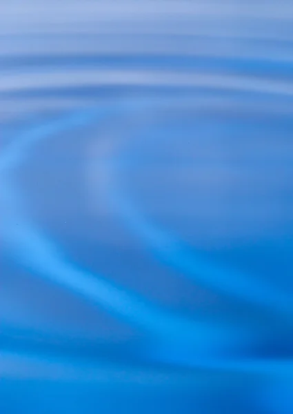 Una gota de agua cayendo en agua azul — Foto de Stock