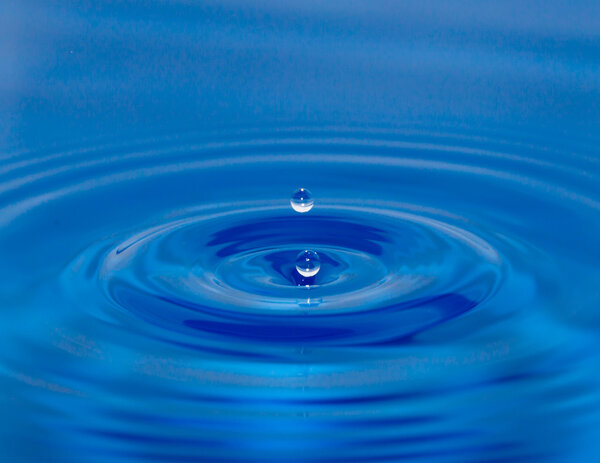 A drop of water falling in blue water