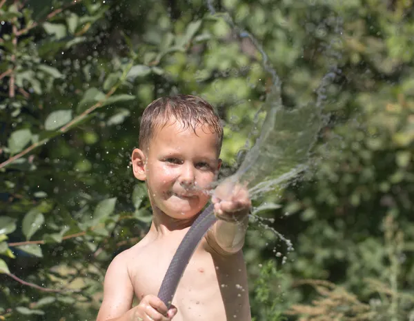 Αγόρι ψεκασμός νερό από τη μάνικα — Φωτογραφία Αρχείου