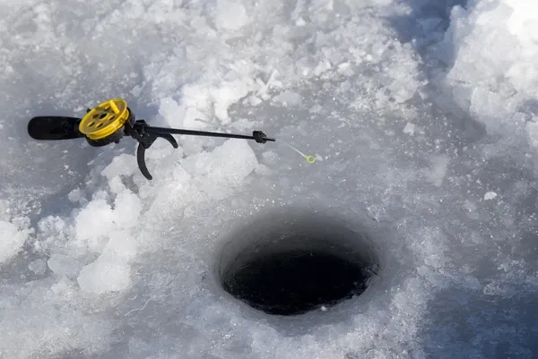 Рыболовная линия в отверстии просверлен во льду — стоковое фото