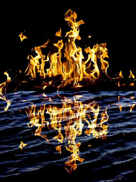 Flammenfeuer mit Reflexion im Wasser — Stockfoto