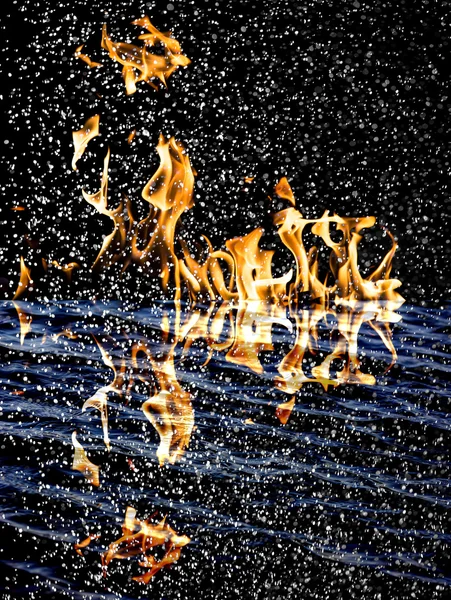 Sníh na pozadí ohně s odrazem na vodě — Stock fotografie
