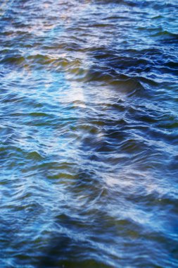 Gökyüzü ve bulutlar su yüzeyine dalga dalga yansıyor.