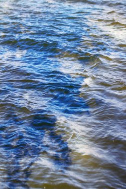 Gökyüzü ve bulutlar su yüzeyine dalga dalga yansıyor.