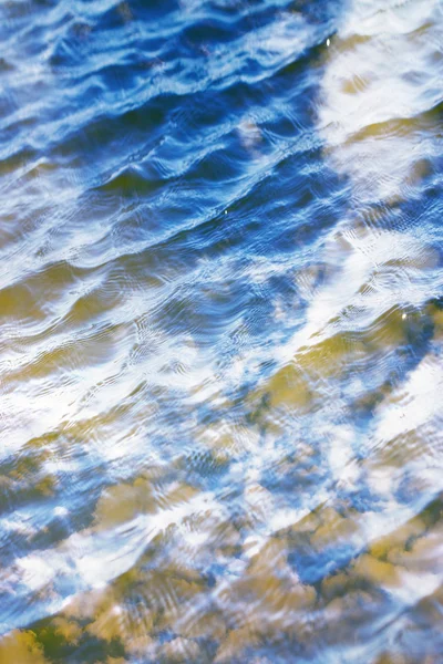 Cielo con nubes reflejadas en la superficie del agua con olas — Foto de Stock