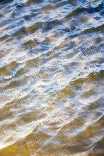 Cielo con nubes reflejadas en la superficie del agua con olas —  Fotos de Stock