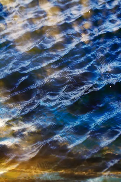 Cielo con nuvole riflesse sulla superficie dell'acqua con onde — Foto Stock
