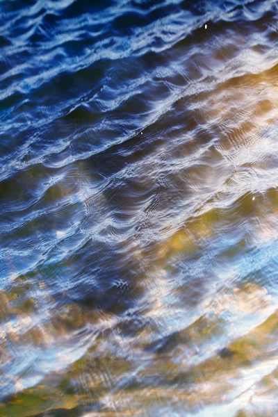 Céu com nuvens refletidas na superfície da água com ondas — Fotografia de Stock