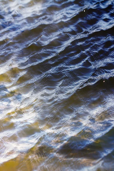 Cielo con nubes reflejadas en la superficie del agua con olas —  Fotos de Stock