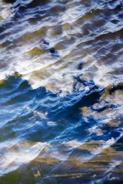 Gökyüzü ve bulutlar su yüzeyine dalga dalga yansıyor. — Stok fotoğraf