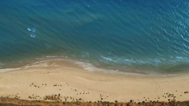 Vista aérea superior do drone de uma praia deserta e as ondas calmas do mar — Vídeo de Stock