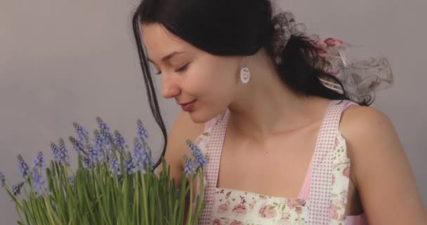 Жінка тримає купу квітів у квітковому горщику в приміщенні — стокове відео