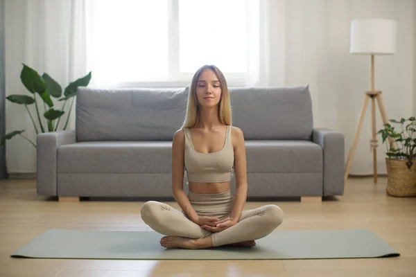 Женщина в медитации по коврику для йоги дома — стоковое фото
