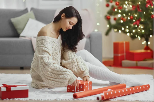 Boże Narodzenie i Nowy Rok prezent zawijania przez kobietę w domu w czasie ferii zimowych — Zdjęcie stockowe