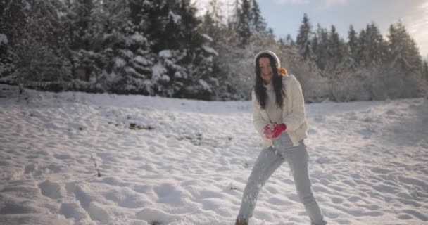 女性は冬のゲームをプレイ,山の森の屋外で雪玉を投げる — ストック動画