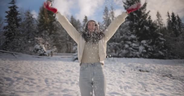 Žena v zimním oblečení házet sníh venku v lese — Stock video