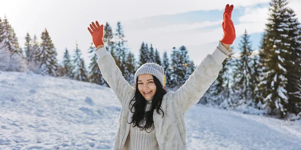 Kvinna i vinterkläder Upphöjda händer utomhus i skogen — Stockfoto