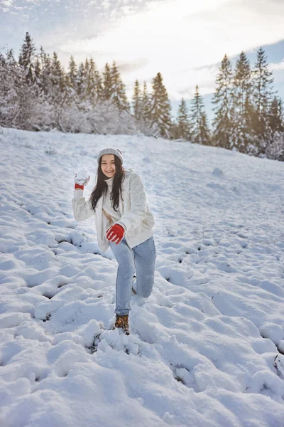 Mujer jugando juego de invierno, lanzando bola de nieve en el bosque de montaña al aire libre — Foto de Stock