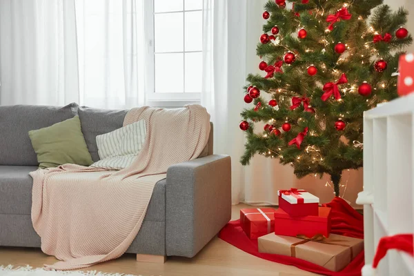 Интерьер рождественского дома. Стильная гостиная с елкой, диваном и подарочными коробками с подарками — стоковое фото