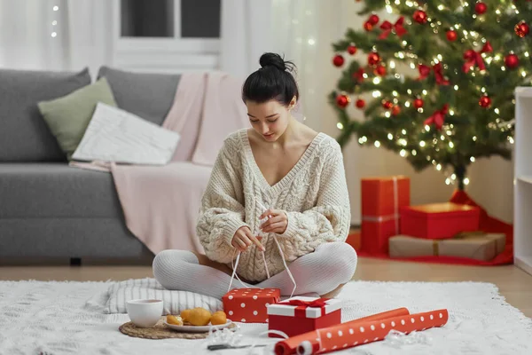 Boże Narodzenie i Nowy Rok prezent zawijania przez kobietę w domu w czasie ferii zimowych — Zdjęcie stockowe