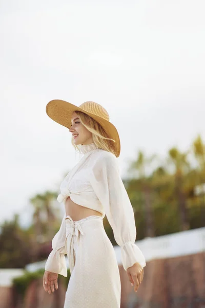 Frau im eleganten Strandoutfit im Sommer draußen vor Palmen im Hintergrund — Stockfoto