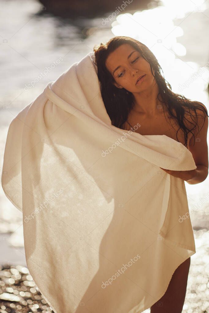 Adorable Beach Woman in the Towel Drying after Swimming on the Deserted Beach During Summer Vacation Outdoors