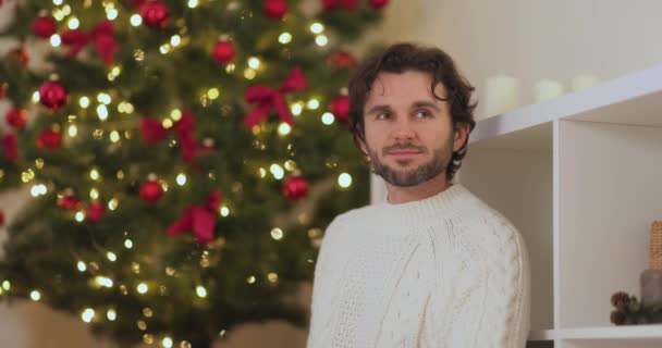 Un bărbat cu prezent în cutia de cadouri de lângă pomul de Crăciun acasă — Videoclip de stoc