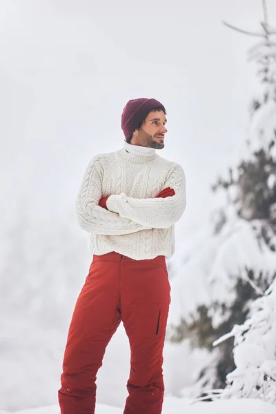 Férfi síöltönyben és pulóverben havas erdőben a téli vakációk alatt szabadban — Stock Fotó