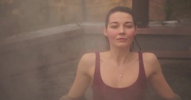 Bikinili bir kadın dışarıda Japon tarzı banyo yapıyor.