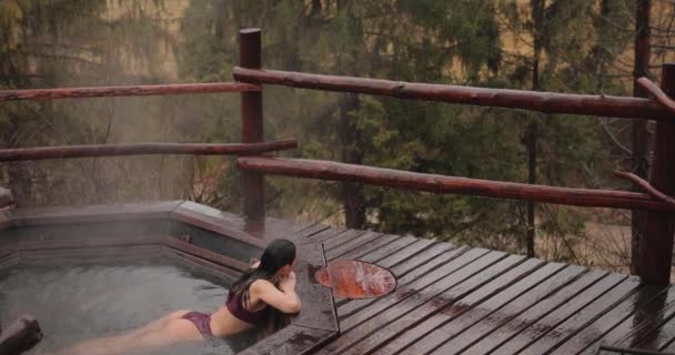 Frau im Bikini badet in japanischem Bad im Freien — Stockvideo