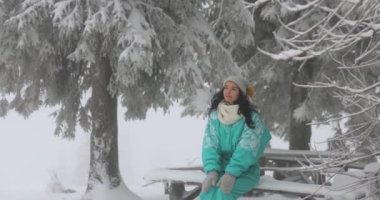 Açık havada kış tatili sırasında karlı ormanda kayak kıyafeti giymiş bir kadın.