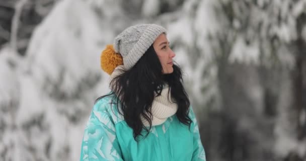 Портрет молодой женщины в лыжном костюме на снежном зимнем фоне во время отпуска на открытом воздухе — стоковое видео