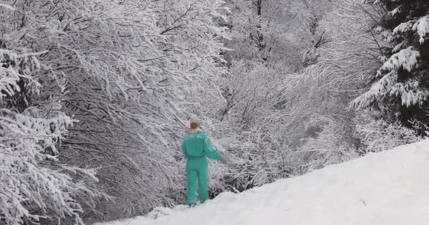 Γυναίκα με κοστούμι σκι στο χιονισμένο δάσος κατά τη διάρκεια των χειμερινών διακοπών σε εξωτερικούς χώρους — Αρχείο Βίντεο