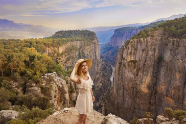 Tourist woman on the edge of a cliff of Tazi Canyon in Manavgat, Antalya, Turkey. Greyhound Canyon, Wisdom Valley. clipart