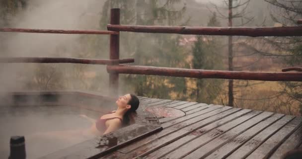 Woman in bikini bathing in wooden bath outdoors — Stock Video