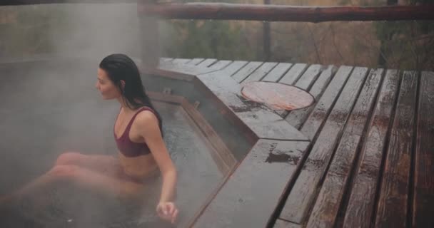 Woman in bikini bathing in wooden bath outdoors — Stock Video