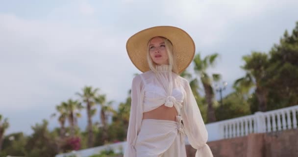 Vrouw in elegante strand outfit buiten tegen palmbomen op de achtergrond tijdens de zomer vakanties — Stockvideo