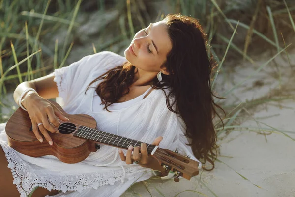 Femme avec Ukulele pendant les vacances d'été à la plage près de la mer — Photo