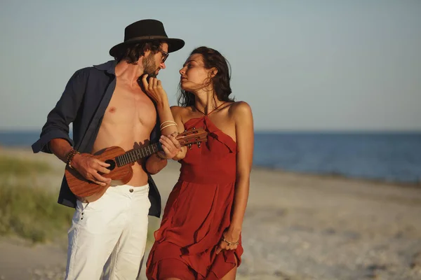 Coppia innamorata che suona la chitarra e balla sulla spiaggia — Foto Stock