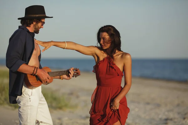 Coppia innamorata che suona la chitarra e balla sulla spiaggia — Foto Stock