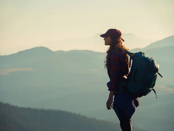 Mulher caminhante com mochila no topo de uma montanha — Fotografia de Stock