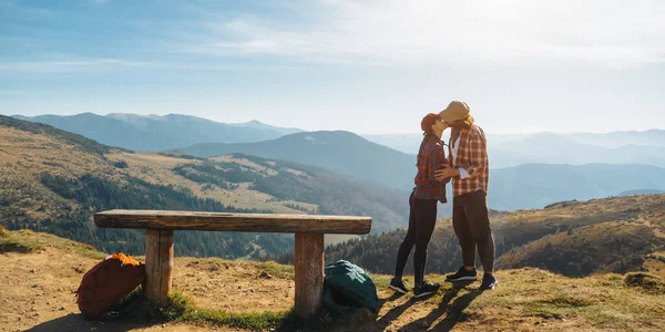 Casal de caminhantes com mochilas na frente da vista do vale da paisagem no topo de uma montanha — Fotografia de Stock