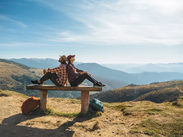 Casal de caminhantes com mochilas na frente da vista do vale da paisagem no topo de uma montanha — Fotografia de Stock