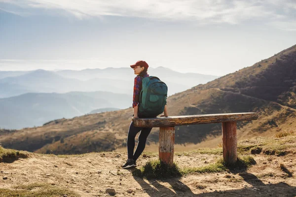 Caminhante feminina com mochila na frente da paisagem vista do vale no topo de uma montanha — Fotografia de Stock