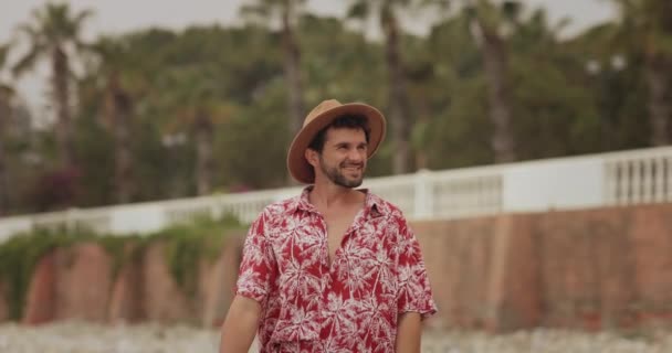 Turiststrandmannen utendørs mot palmetrær på bakgrunn av sommerferier – stockvideo